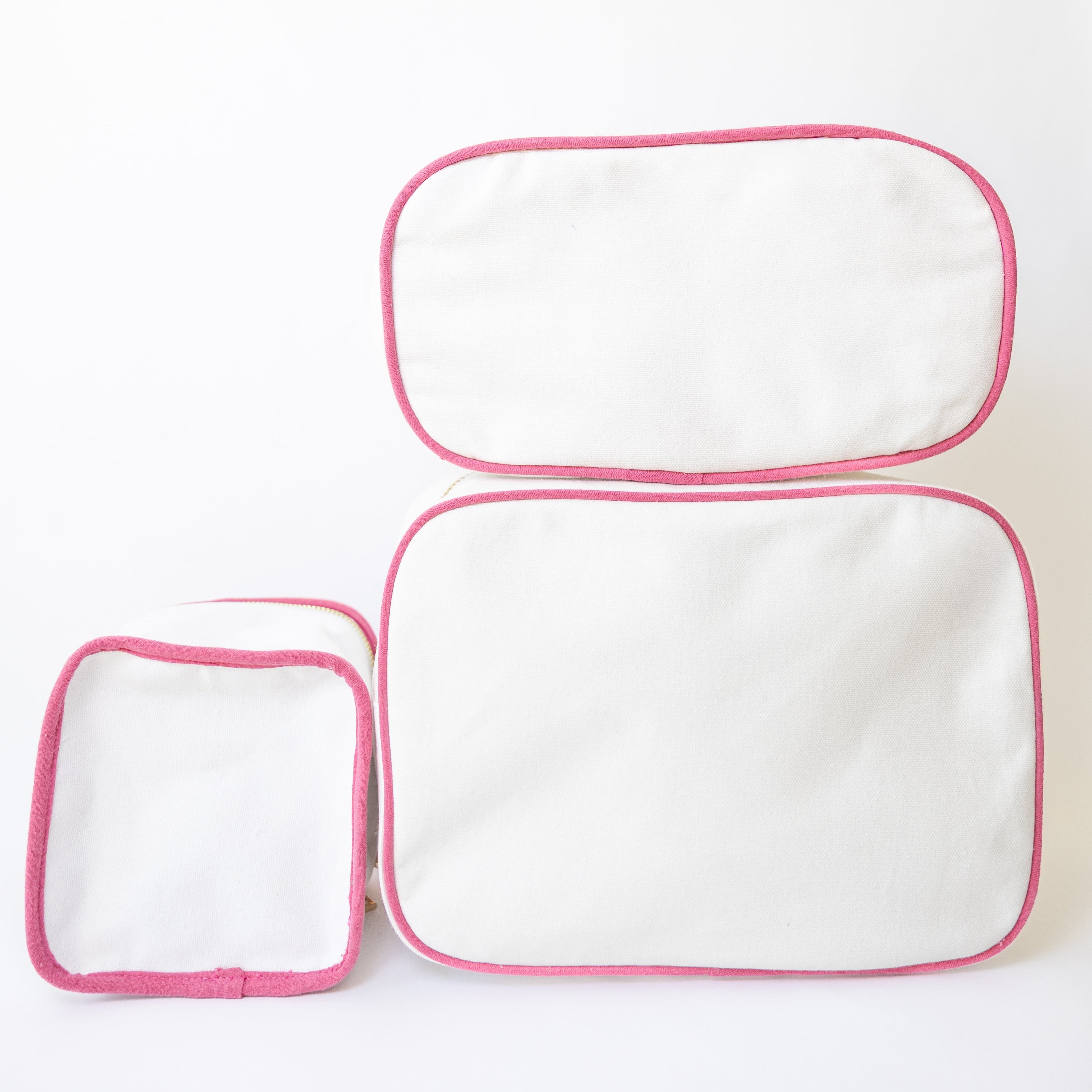 Two white pouches with pink zippers on a white background